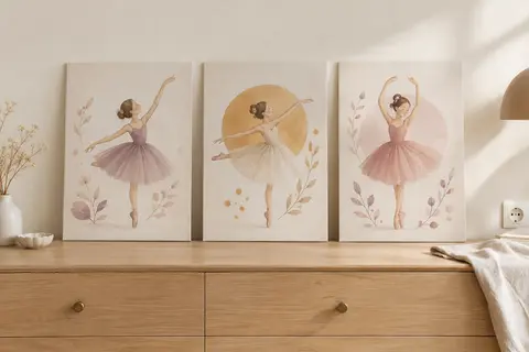 Trois affiches sur toile illustrées de danseuses, posées sur une commode en bois clair contre un mur ivoire.